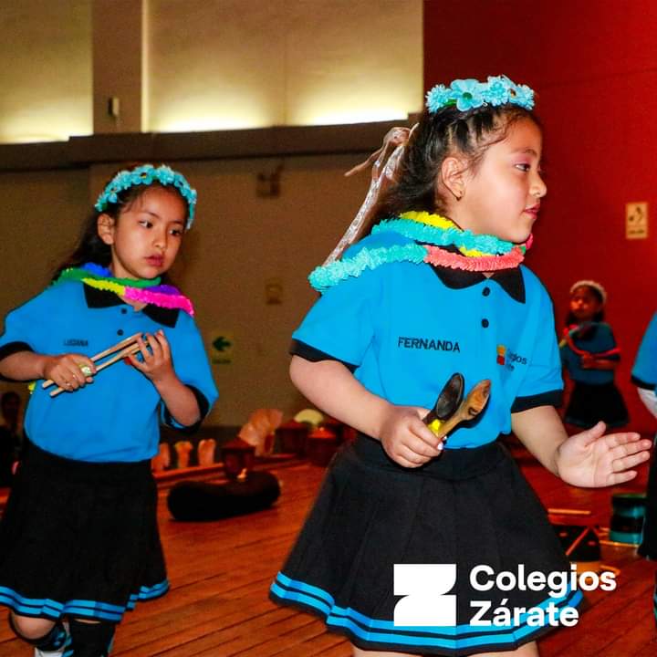 Niñas cantando con instrumentos de percusión